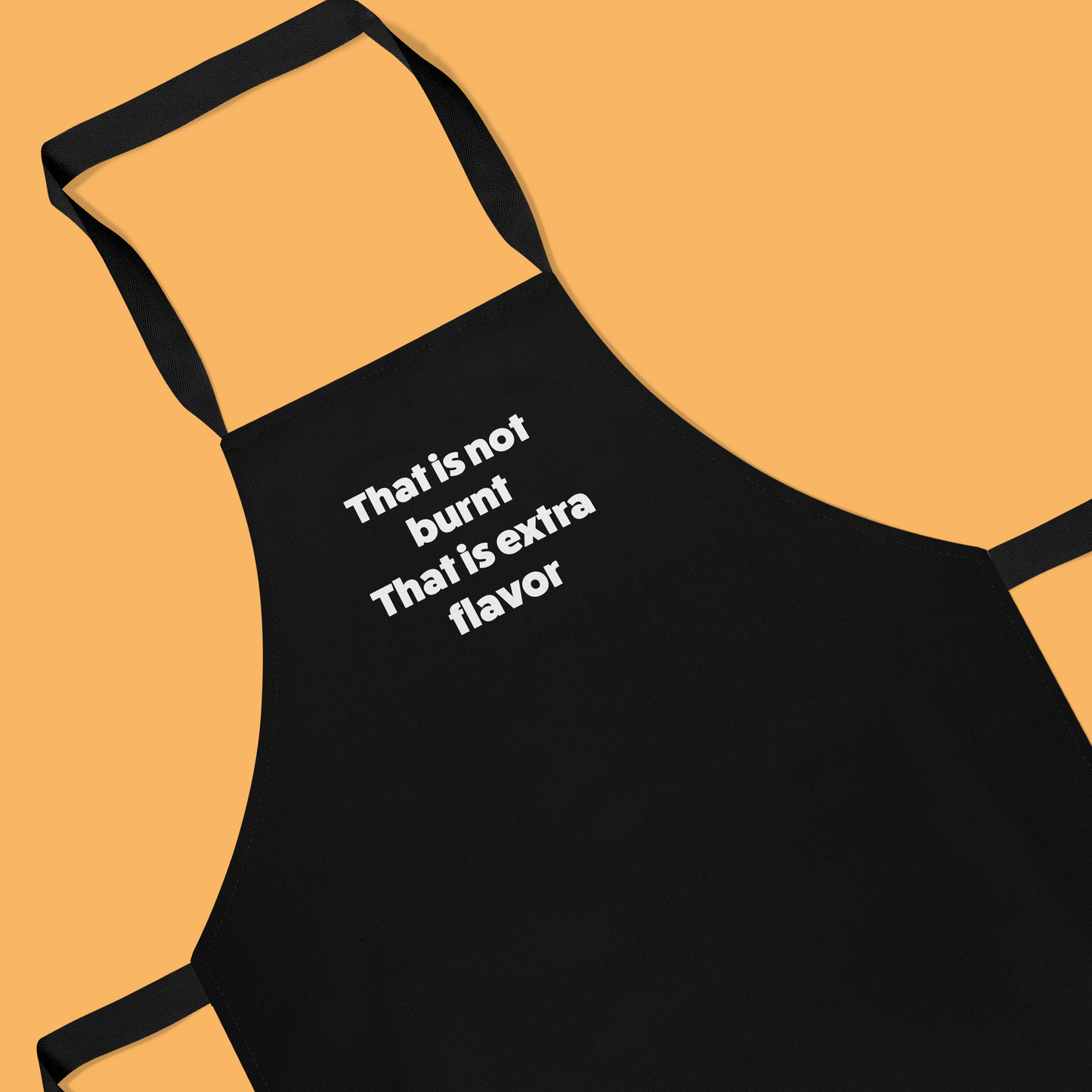Keukenschort zwart met grappige tekst - It’s not burnt. It’s extra flavour